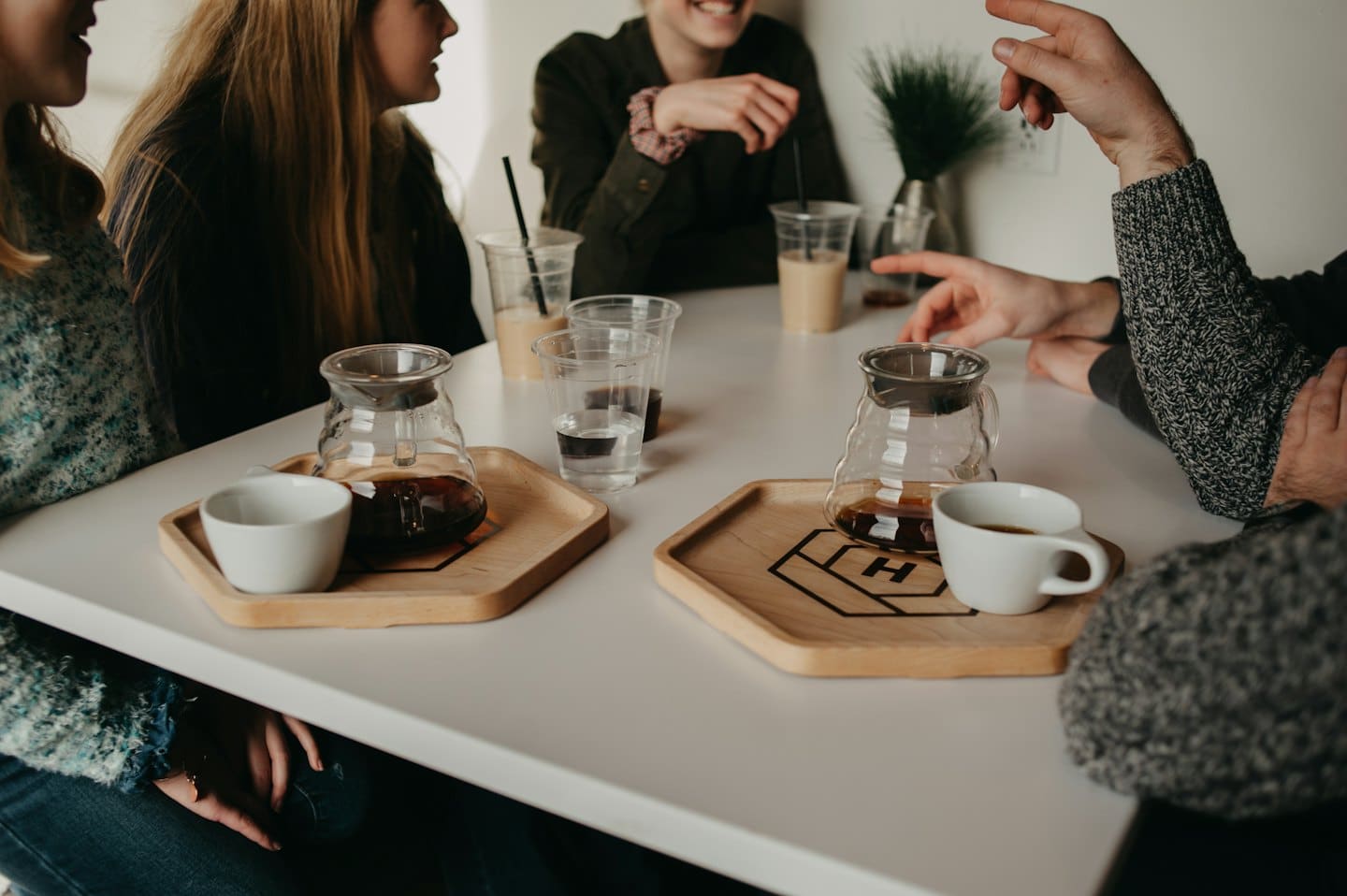 People chatting over coffee at a cafe table.
